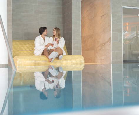 Paar sitzt beim Pool Hotel Leonhard